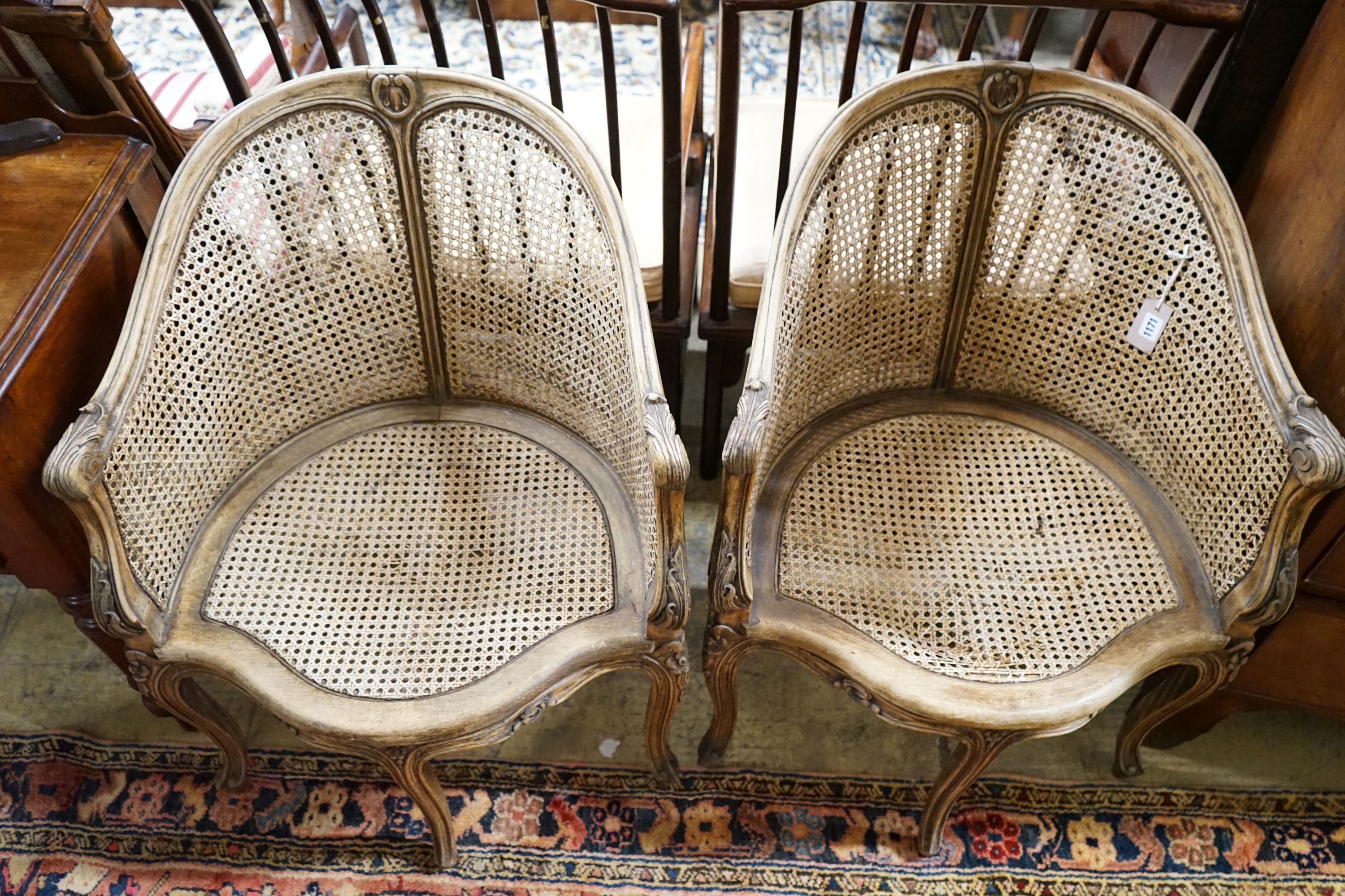 A pair of early 20th century French caned, carved beech Bergere chairs